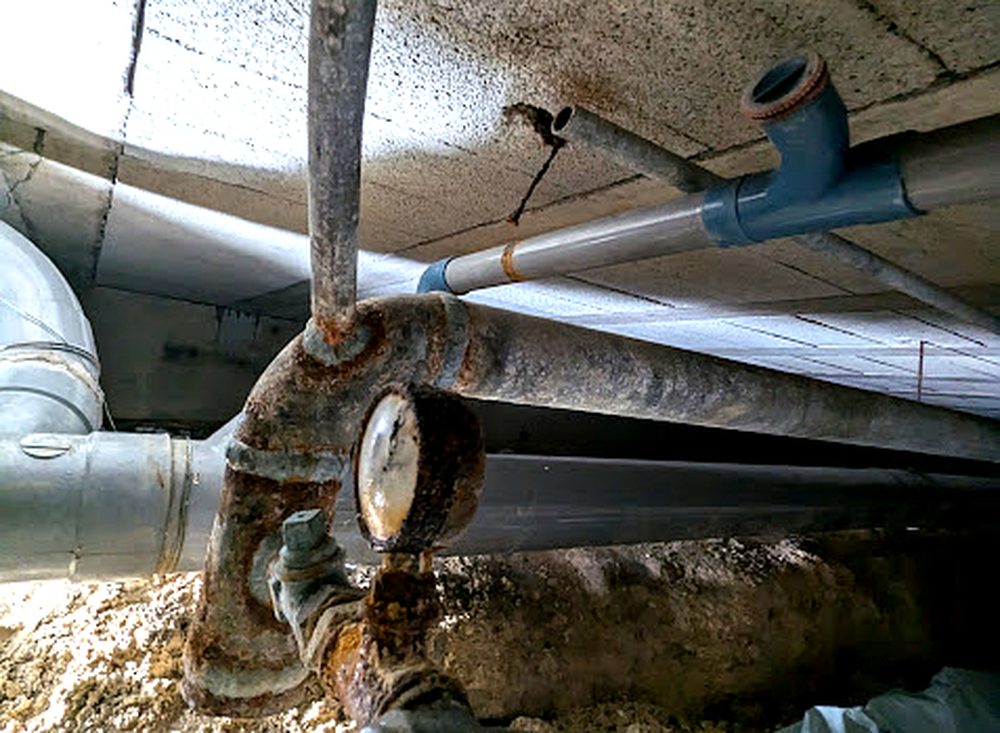 Colonne d'eau froide corrodée en vide sanitaire avant intervention